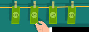 Illustration of a hand reaching towards four green dollar bills hanging on a clothesline with clothespins, against a blue background.